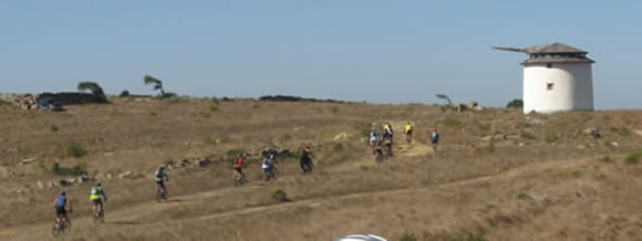 ciclistas a subir um trilho em direc��o a um moinho perto de Odrinhas
