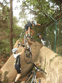 ciclistas a saltar um muro com as bicicletas