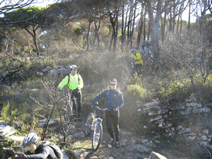 v�rias fotos com os ciclista a levarem a bicicletas � m�o no meio do mato e sem caminho