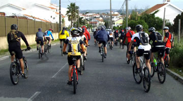 grupo de ciclista a descer uma estrada para sacotes