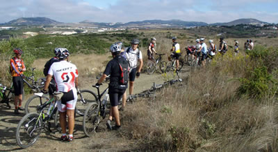 grupo de ciclista parado no monte com a zona de negrais ao fundo