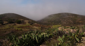 vista da serra sobre a zona do guincho com dois montes no nevoeiro