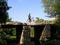 Ciclista sobre ponte antiga em pedra no vale da cabrela num das nossas voltas