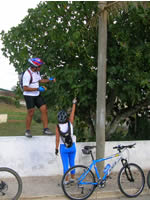 ciclistas a subirem a um muro para apanharem figos para comer