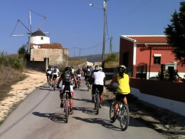 grupo pedalando perto de um moinho